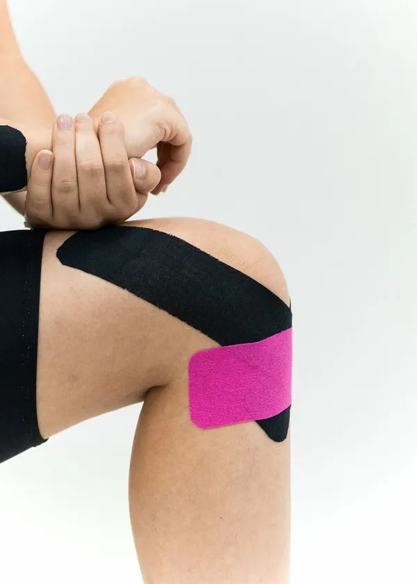 Rodilla con vendaje neuromuscular de colores aplicado